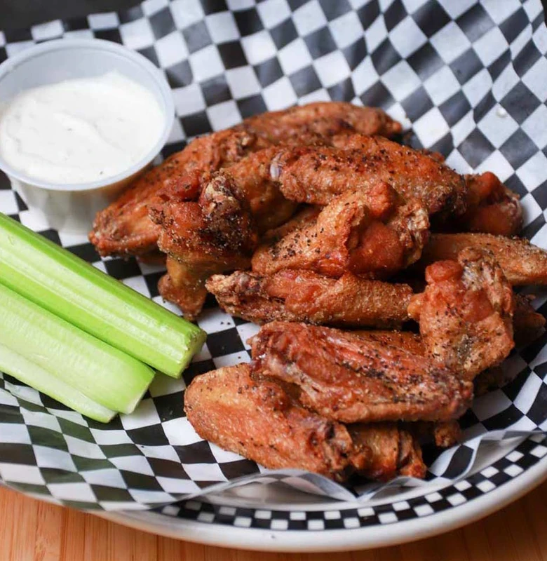 Crispy chicken wings tossed in sauce at Monty's Pizza in Edmonton, AB
